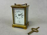 une petite horloge et une clé posées sur une table