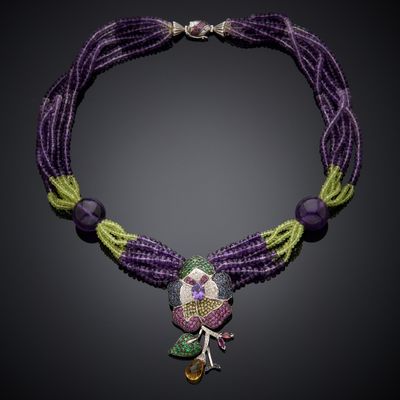 a close up of a purple necklace with green and purple beads