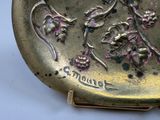 a gold plate with a picture of a woman and flowers on it