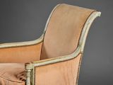 a chair with a beige upholstered cushion and a gold trim