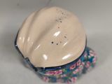 a small bowl with a lid on a white surface