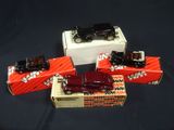 three toy cars are sitting in a box on a black surface
