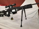the rifle is sitting on a white sheet with a gun on it