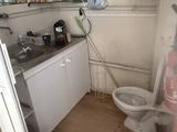a bathroom with a toilet, sink, and other items in it