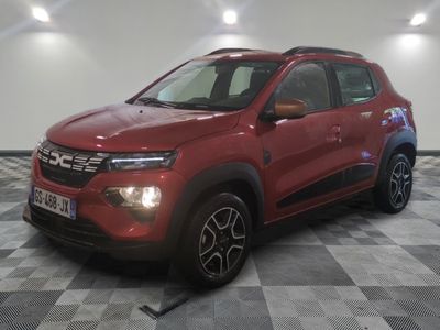 une voiture rouge est garée dans une pièce au sol en damier