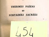 un vieux livre sur lequel est collée une note, elle-même recouverte d'un autocollant