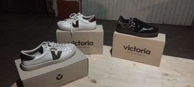 three pairs of white and black shoes sitting on top of boxes