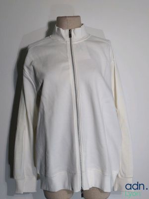 the white jacket is on a mannequin stand against a white wall