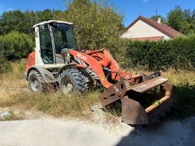 un tracteur qui est garé dans l'herbe près d'une maison