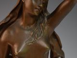 bronze statue of a woman holding a bird on a marble base