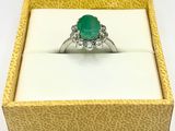 an image of a ring with a green stone in a box