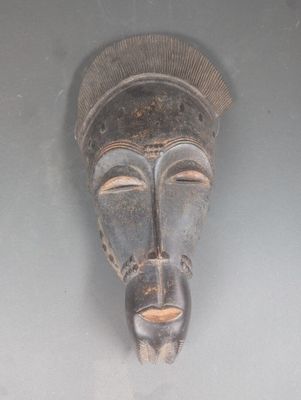 un masque en bois accroché au mur d'une pièce