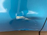 a close up of a person ' s foot on a blue car