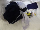 a pile of clothes on a bed next to a cell phone