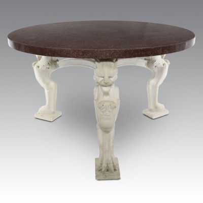 a white table with a marble top and two statues on it