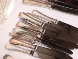 a lot of silverware on a table with spoons and forks
