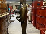 a bronze statue of a person standing in a room