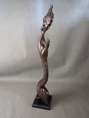 statue en bronze d'une femme tenant un oiseau sur une base en bois
