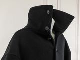 an image of a black coat hanging on a white wall
