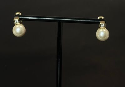 Paire de boucles d'oreilles dormeuses en métal doré ornés d'…