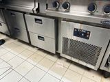 Plusieurs appareils électroménagers en acier inoxydable sont alignés sur un sol carrelé