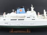 une maquette de bateau posée sur un socle, sur fond noir