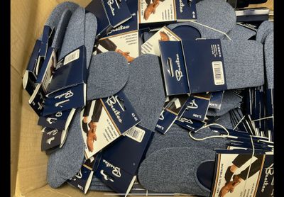 many pairs of socks in a box with tags on them