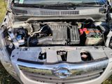 the engine of a car with its hood open in the grass