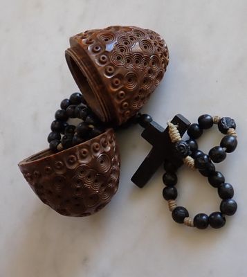 a wooden object with a cross and a rosary on a table