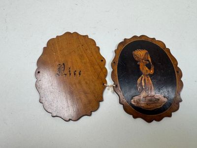 deux plaques en bois représentant une femme tenant un parapluie