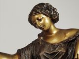 a bronze statue of a woman holding a dog