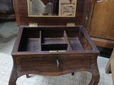 a small wooden table with a mirror on top of it