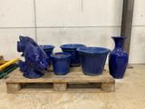 many blue vases sitting on a pallet next to each other