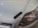 a close up of a white car with a sticker on it ' s hood
