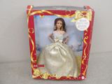 doll in a box with a gold dress and gold earrings