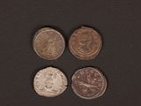 four different types of coins on a black surface