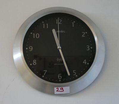 une horloge accrochée au mur sur laquelle est collé un autocollant