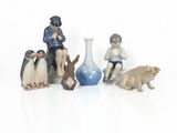 several figurines of people and animals sitting on a white surface