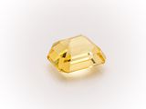 a close up of a yellow diamond on a white surface