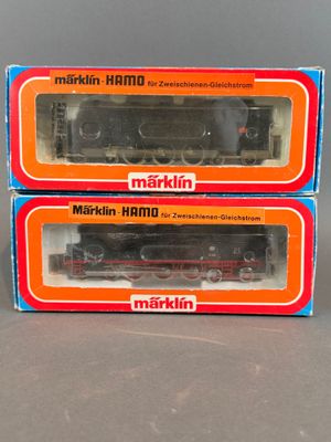 Deux cartons contenant des trains Märklin sont posés sur une table