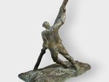 bronze sculpture of a man holding a baseball bat on a rock