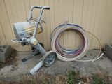 a machine that is sitting on the ground next to a hose
