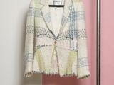 the jacket is hanging on a hanger in front of a pink and white wall