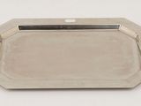 a silver tray with a handle on a white surface