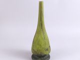 un vase vert posé sur une surface blanche