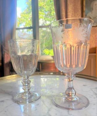 deux verres à vin posés sur une table devant une fenêtre