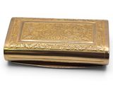 a gold box that is sitting on a white surface