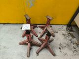 four wooden chairs sitting on the floor next to a yellow wall