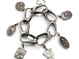 bracelet en argent orné de breloques religieuses et d'autres breloques sur fond blanc