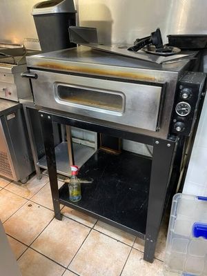 an oven sitting in the middle of a kitchen next to a stove